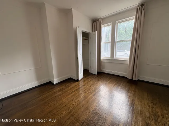 an empty room with wooden floor and closet