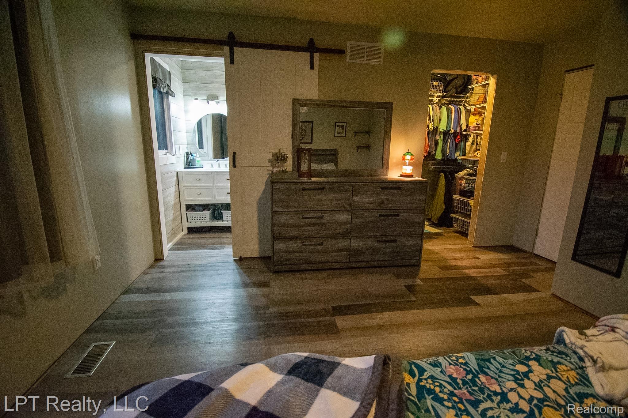 217 Nawakwa Road Rochester, MI 48307 - Photo 13 of 29 Bedroom featuring a barn door, Laminate wood finished floors, a walk in closet, and ensuite bathroom