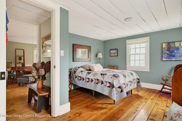 a bedroom with bed and wooden floor