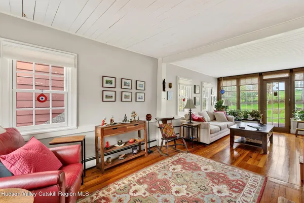 a living room with furniture a rug and a floor to ceiling window