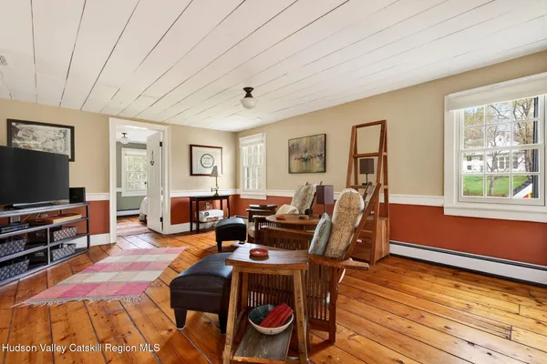 a living room with furniture a flat screen tv and a window