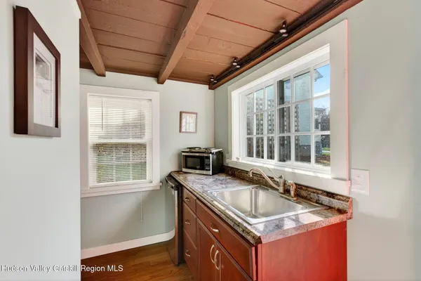 a sink a granite counter top a window and chairs