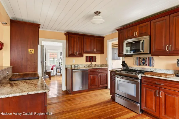 a kitchen with stainless steel appliances granite countertop wooden cabinets a stove top oven a sink and dishwasher