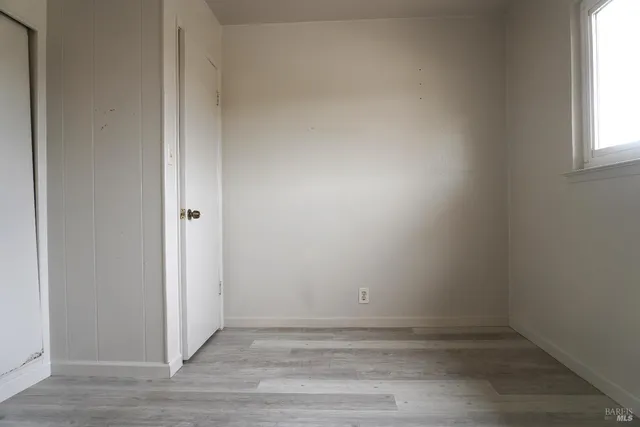 an empty room with a window and wooden floor