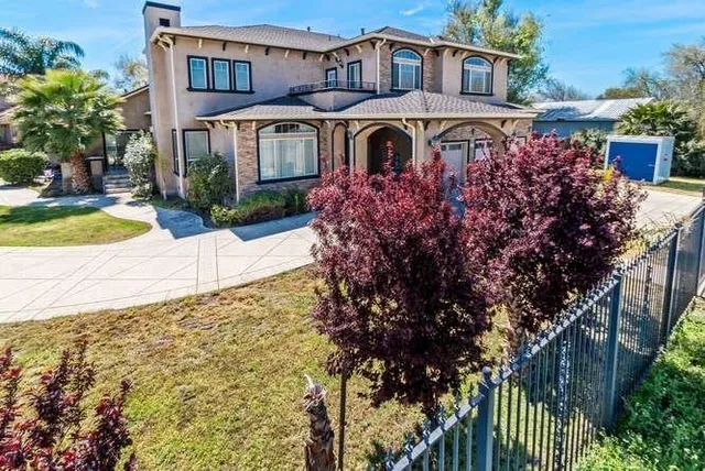 a front view of a house with a yard and fountain