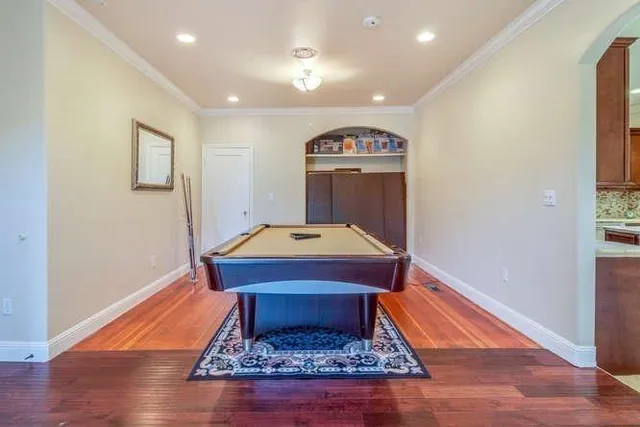 a room with pool table and wooden floor