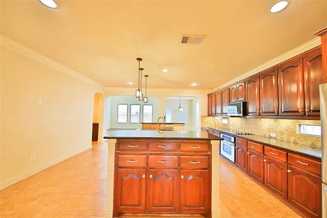 a kitchen with stainless steel appliances granite countertop a stove a sink and a refrigerator