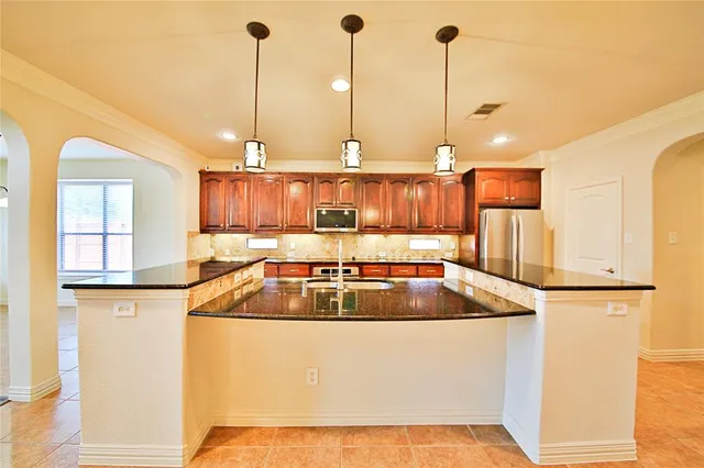 a kitchen with stainless steel appliances granite countertop a sink and stove