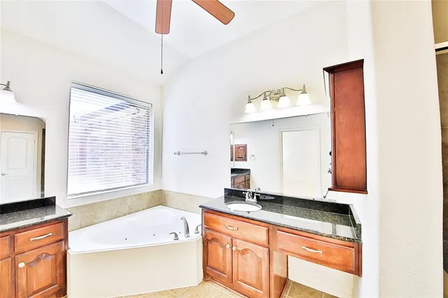a spacious bathroom with a granite countertop sink and a mirror