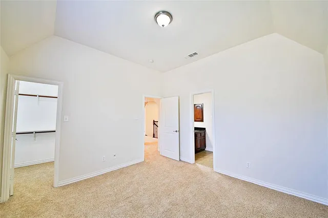 a view of an empty room with a chandelier fan