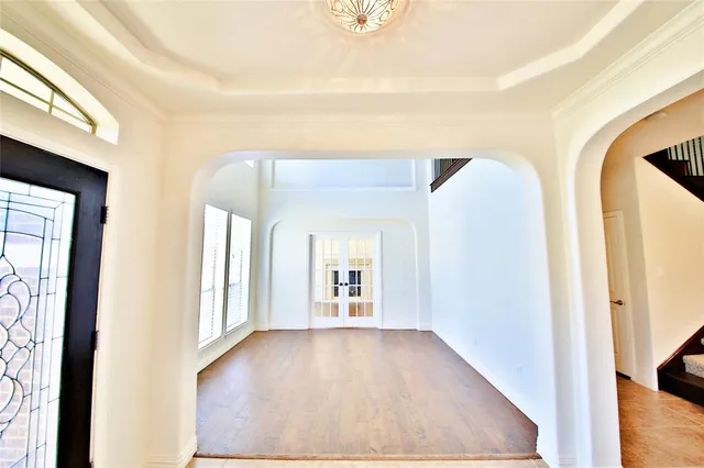 a view of a hallway with wooden floor and a living room