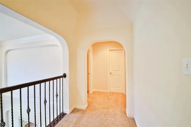 a view of an empty room with chandelier fan