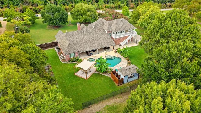 an aerial view of a house with swimming pool garden and patio
