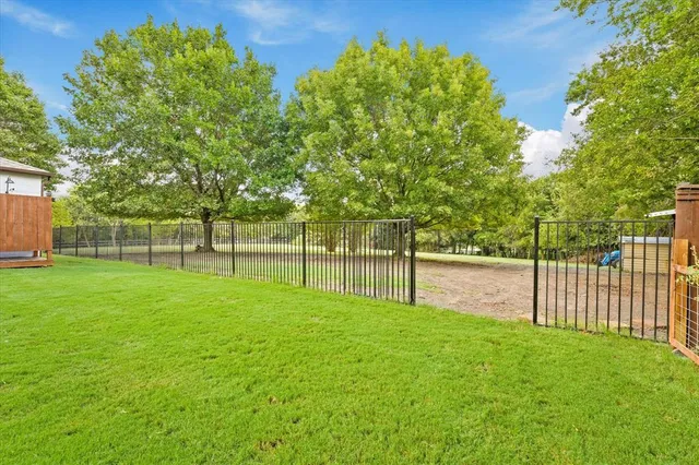 a view of a patio with table and chairs with wooden floor and fence