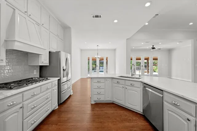 a large kitchen with stainless steel appliances granite countertop a stove a sink and a refrigerator