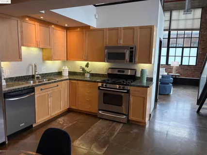 a kitchen with stainless steel appliances granite countertop a stove a sink and a microwave