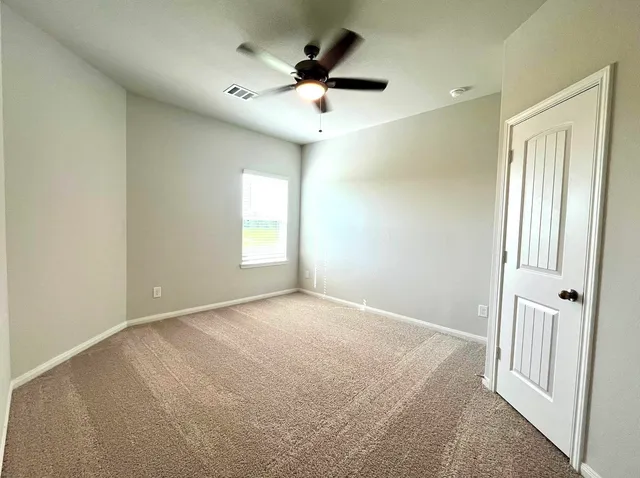 an empty room with fan and windows