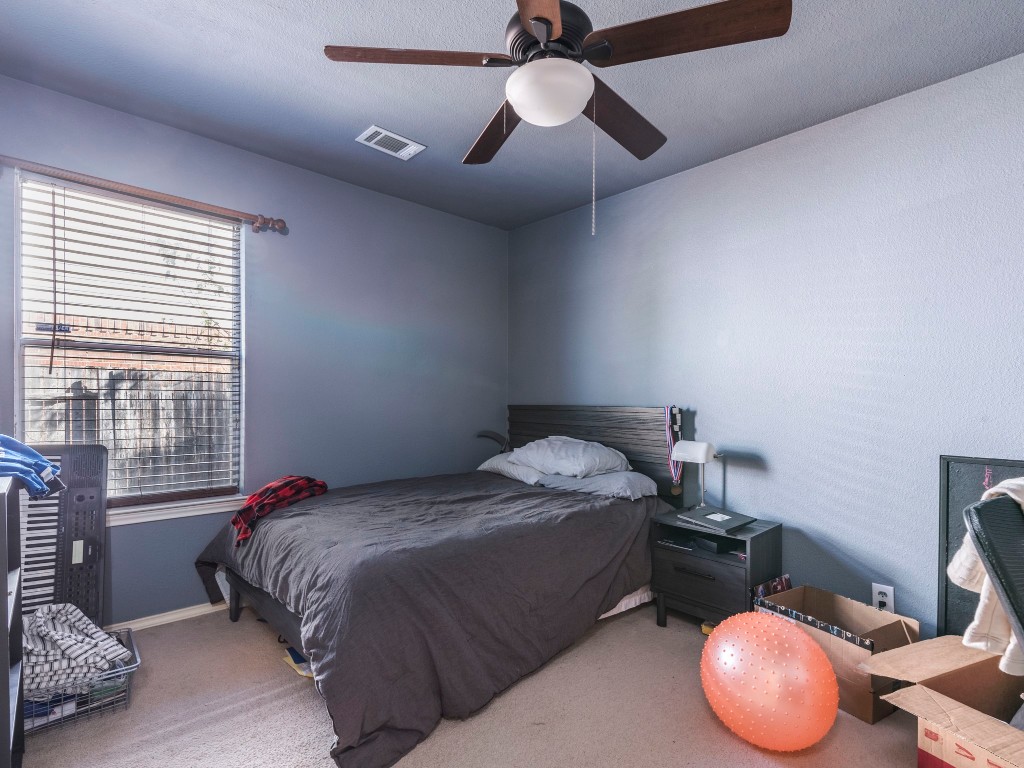 172 Winter Street Kyle, TX 78640 - Photo 10 of 14 a bedroom with a bed and a chandelier