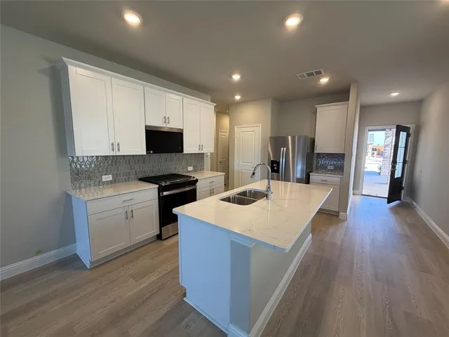 a large kitchen with sink a microwave a stove and refrigerator