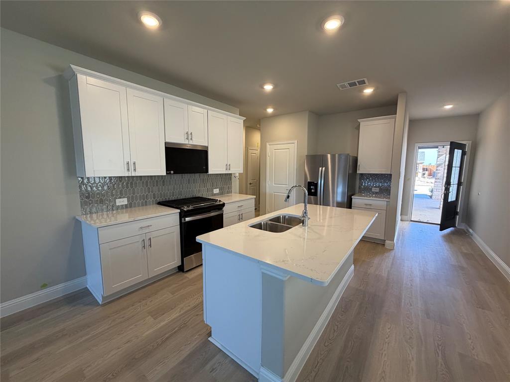 1740 Arches Road Anna, TX 75409 - Photo 3 of 7 a large kitchen with sink a microwave a stove and refrigerator