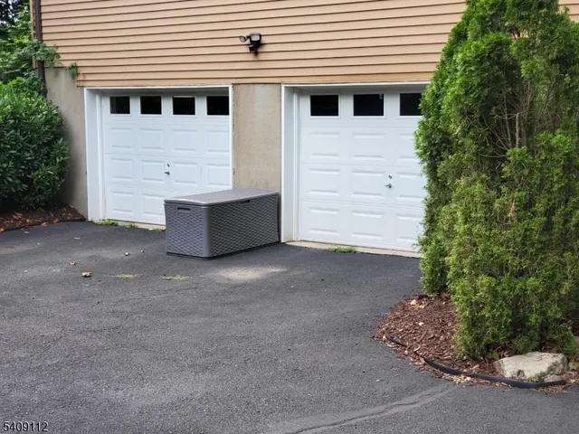 a view of a white house with a yard and garage