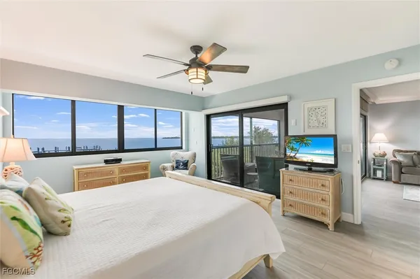 a bedroom with a bed a large window and mirror