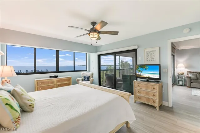 a bedroom with a bed a large window and mirror