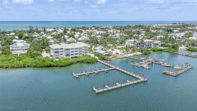 an aerial view of residential houses with outdoor space and lake view