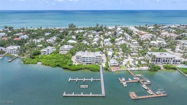 an aerial view of ocean and residential houses with outdoor space