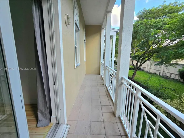 a bedroom with a bed lamp and a large window with wooden floor