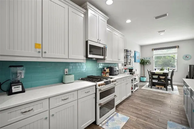 a bathroom with a granite countertop sink two mirror and shower