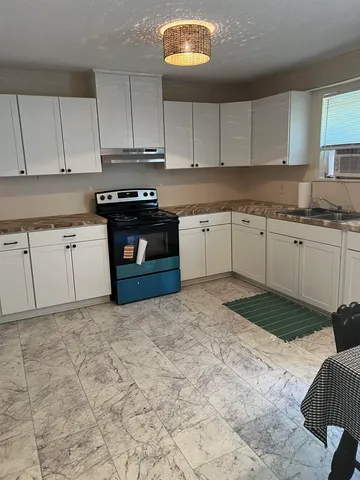 a kitchen with granite countertop a stove a sink and a granite counter tops