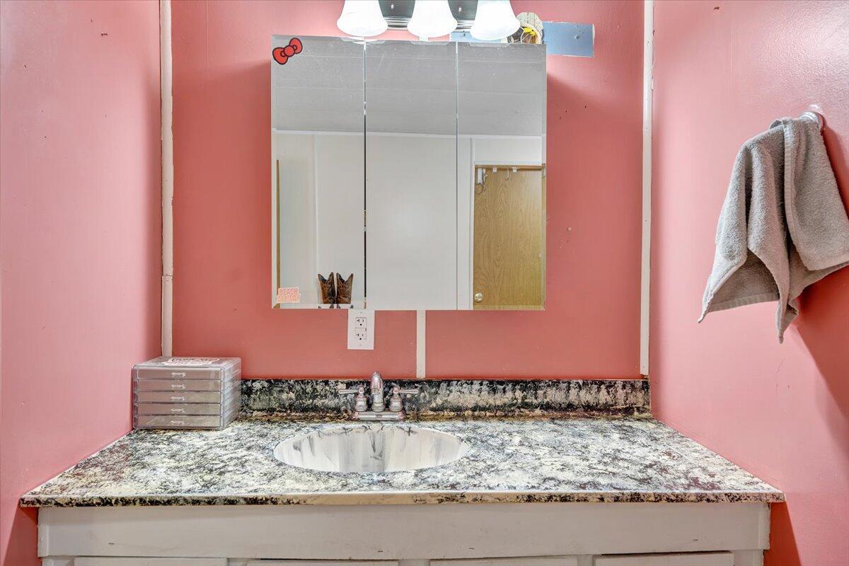 164 Tabernacle Road Penhook, VA 24137 - Photo 20 of 58 a bathroom with a granite countertop sink and a mirror