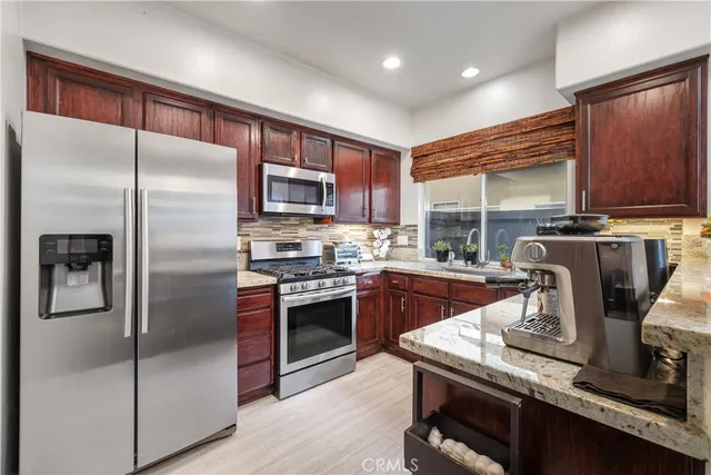 a kitchen with kitchen island granite countertop a refrigerator stove and sink