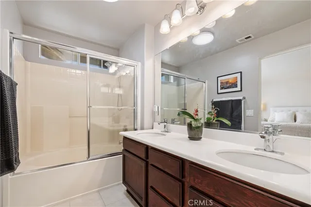 a bathroom with a double vanity sink mirror and shower