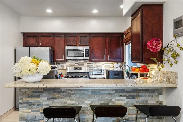 a kitchen with granite countertop a stove and cabinets