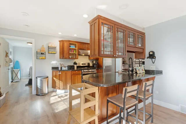 a kitchen with stainless steel appliances granite countertop a refrigerator and a stove top oven