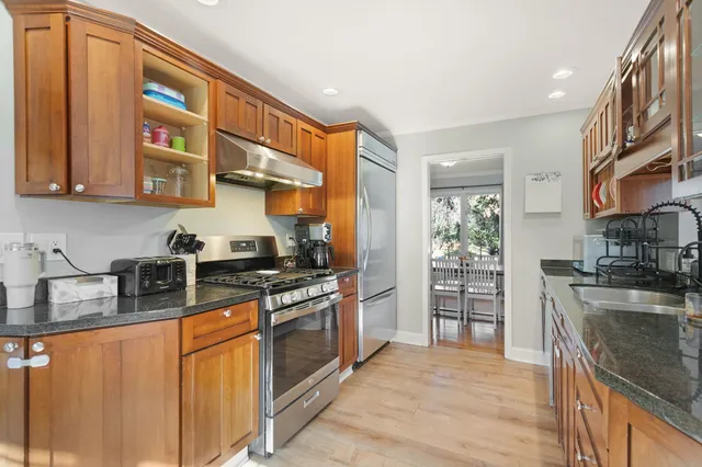 a kitchen with stainless steel appliances granite countertop a stove a sink and a refrigerator