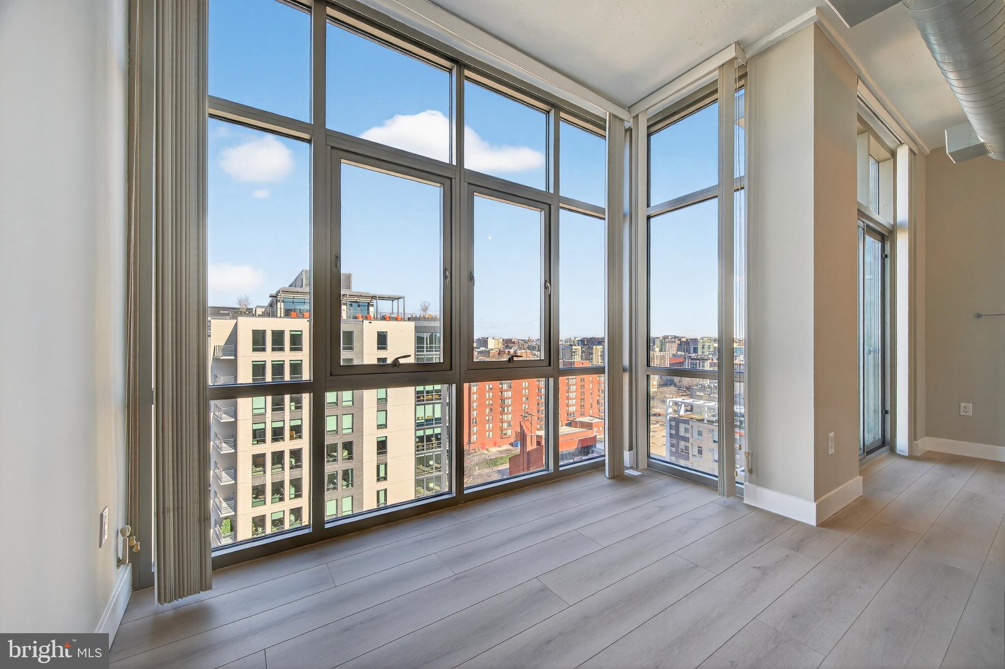 811 4th Street Northwest, Unit 1215 Washington, DC 20001 - Photo 12 of 32 an empty room with wooden floor and windows