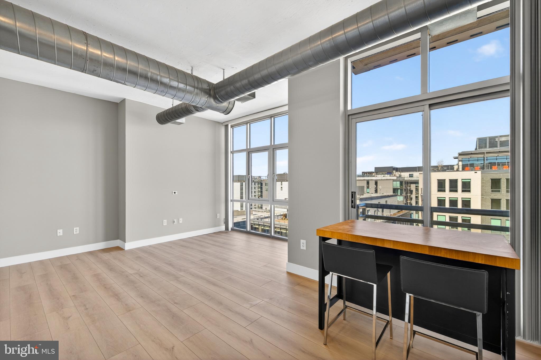 811 4th Street Northwest, Unit 1215 Washington, DC 20001 - Photo 13 of 32 a dining room with wooden floor and large windows