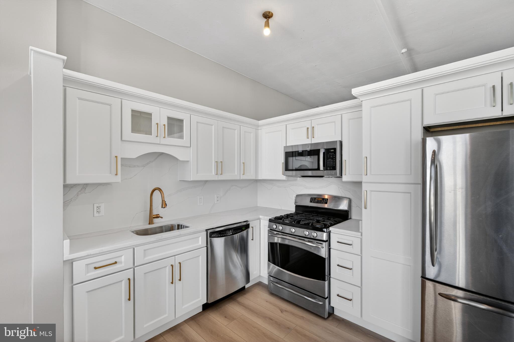 811 4th Street Northwest, Unit 1215 Washington, DC 20001 - Photo 16 of 32 a kitchen with white cabinets stainless steel appliances and a sink