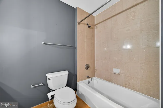 a bathroom with a granite countertop toilet sink and mirror