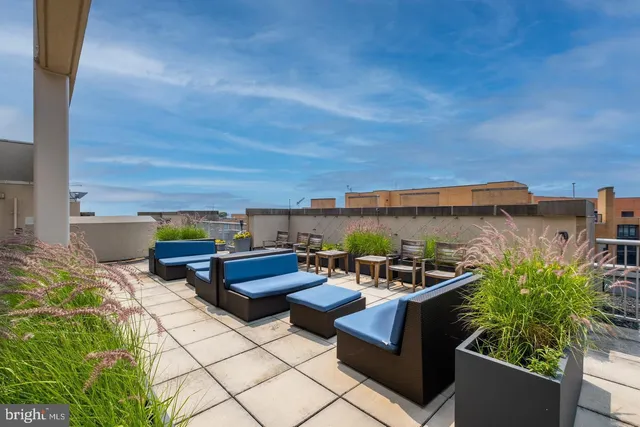 a roof deck with table and chairs a barbeque
