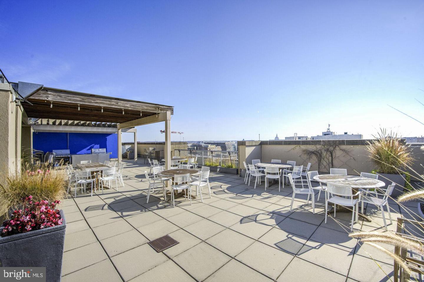 811 4th Street Northwest, Unit 1215 Washington, DC 20001 - Photo 28 of 32 a roof deck with table and chairs a barbeque