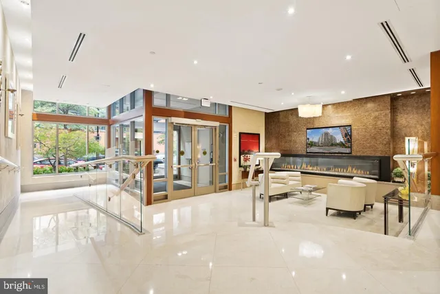 a living room with furniture a flat screen tv and a large window