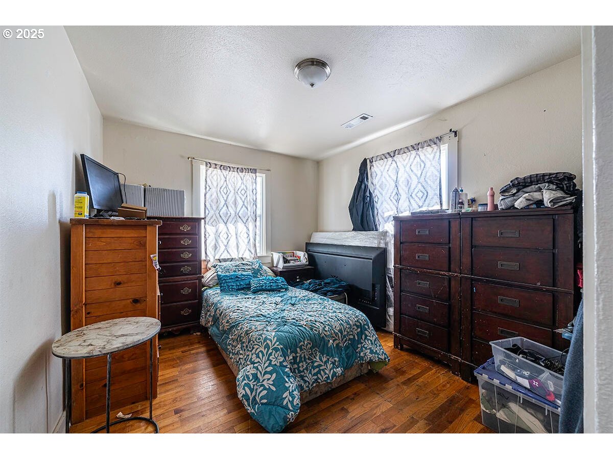 176 Reager Street Medford, OR 97501 - Photo 28 of 48 a bedroom with a bed and wooden floor