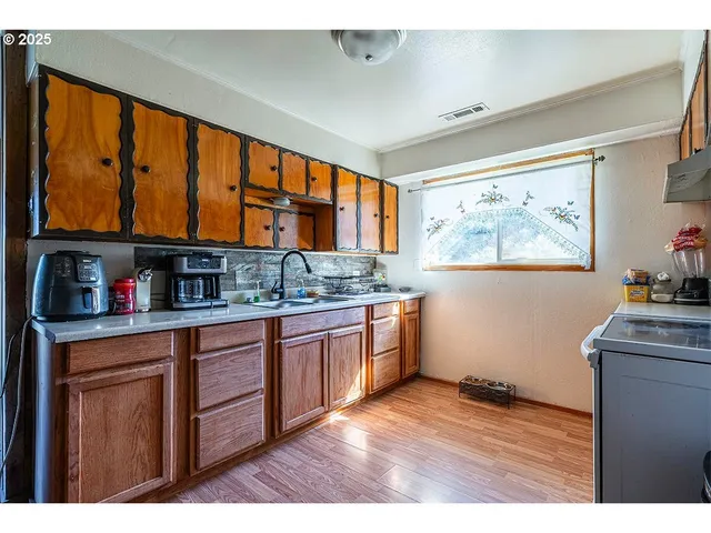 a kitchen with stainless steel appliances granite countertop a stove a sink dishwasher and a refrigerator