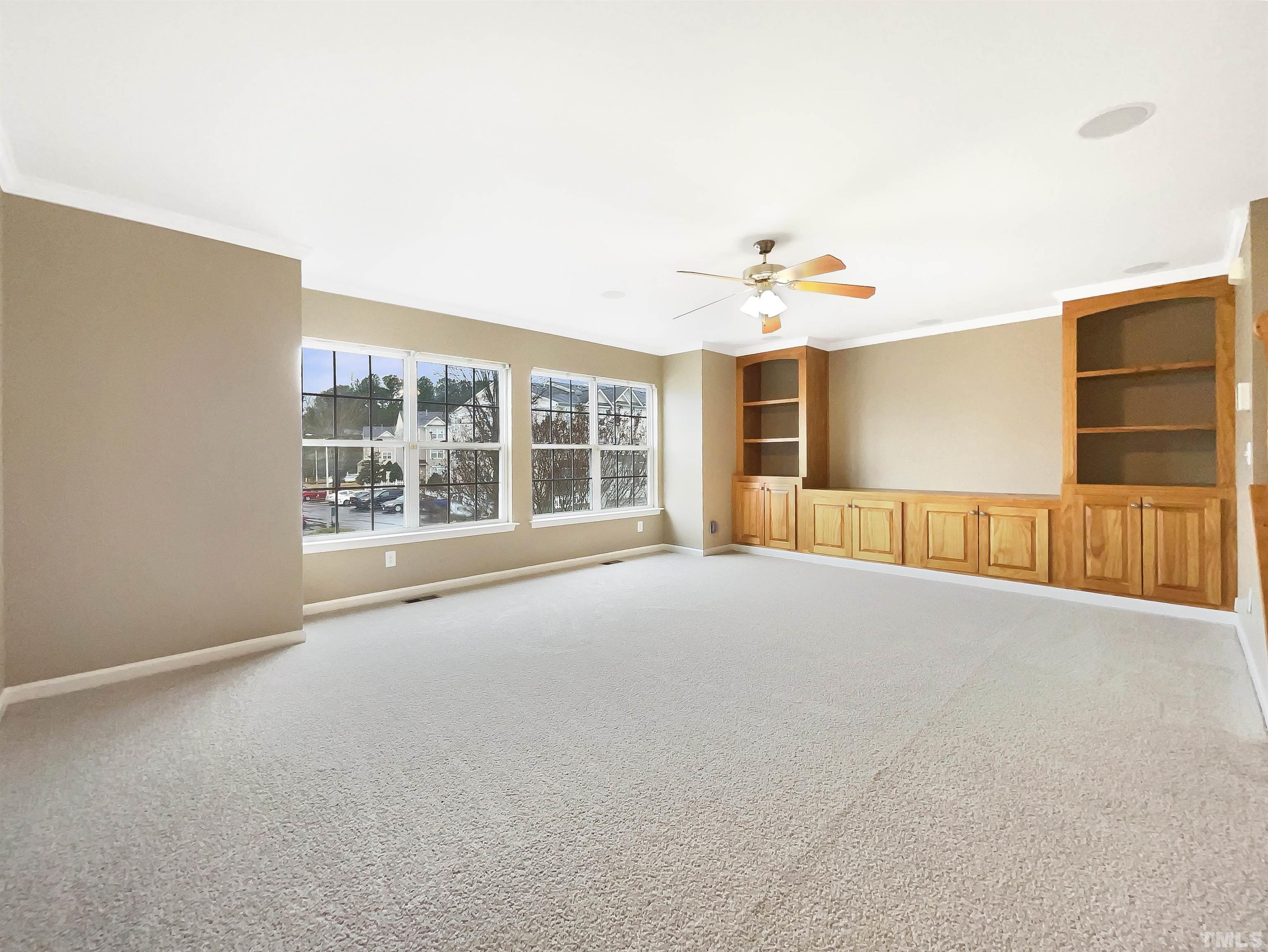 5115 Neuse Commons Lane Raleigh, NC 27616 - Photo 3 of 22 an empty room with windows and ceiling fan