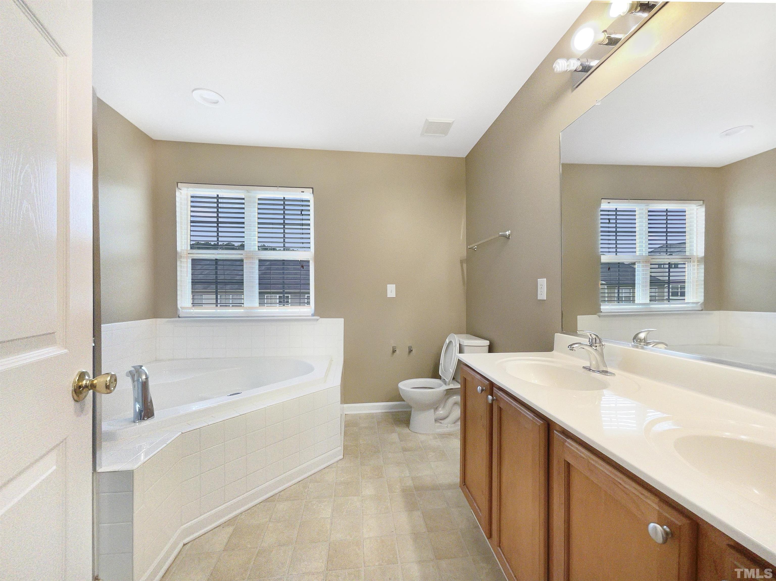 5115 Neuse Commons Lane Raleigh, NC 27616 - Photo 4 of 22 a spacious bathroom with a tub sink and mirror