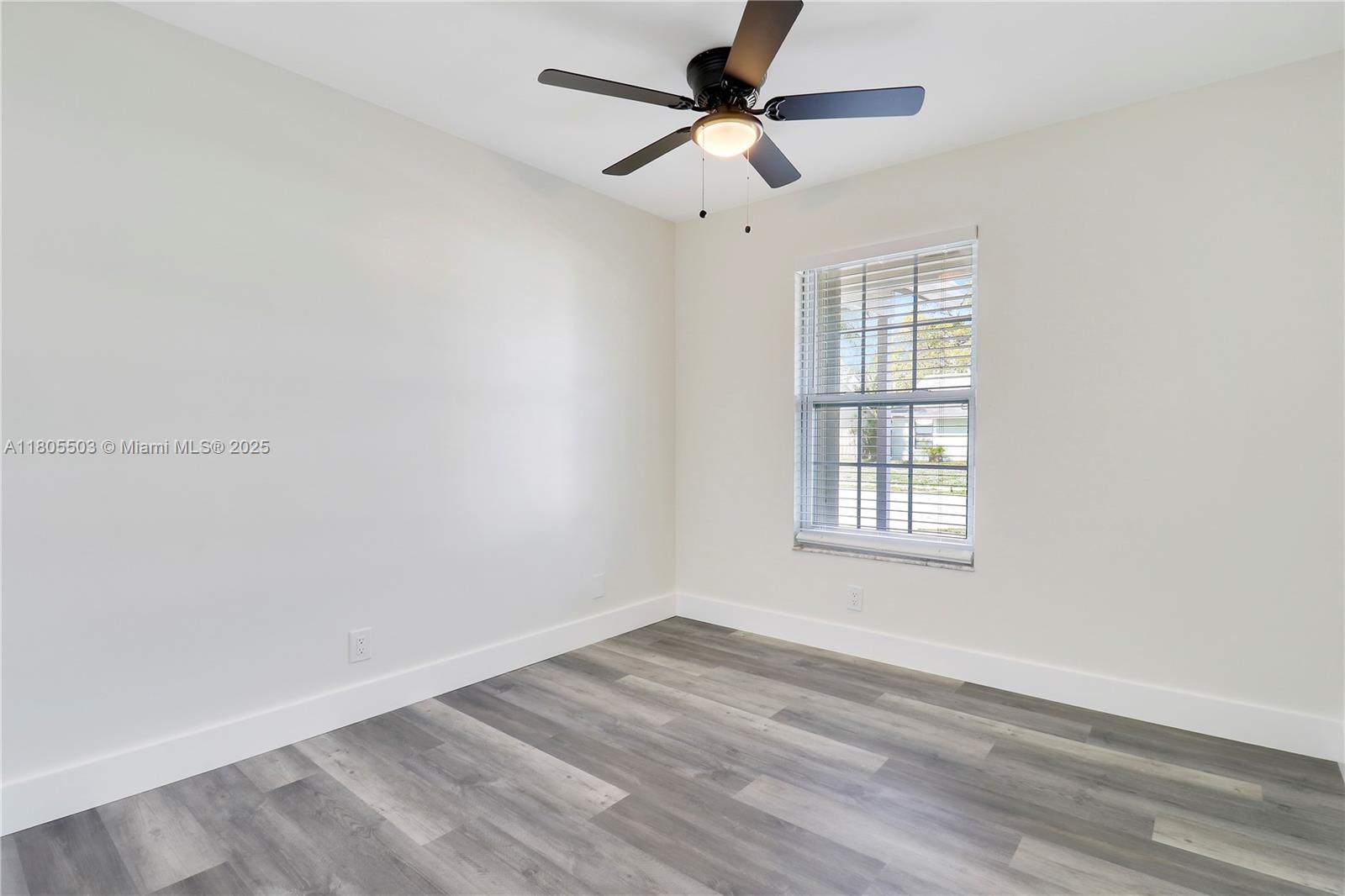 143 Greentree Circle Jupiter, FL 33458 - Photo 12 of 16 an empty room with wooden floor fan and windows